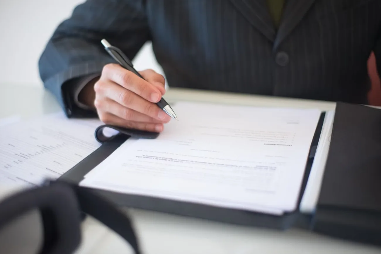 Roofer documenting inspection findings on paperwork before providing any pricing