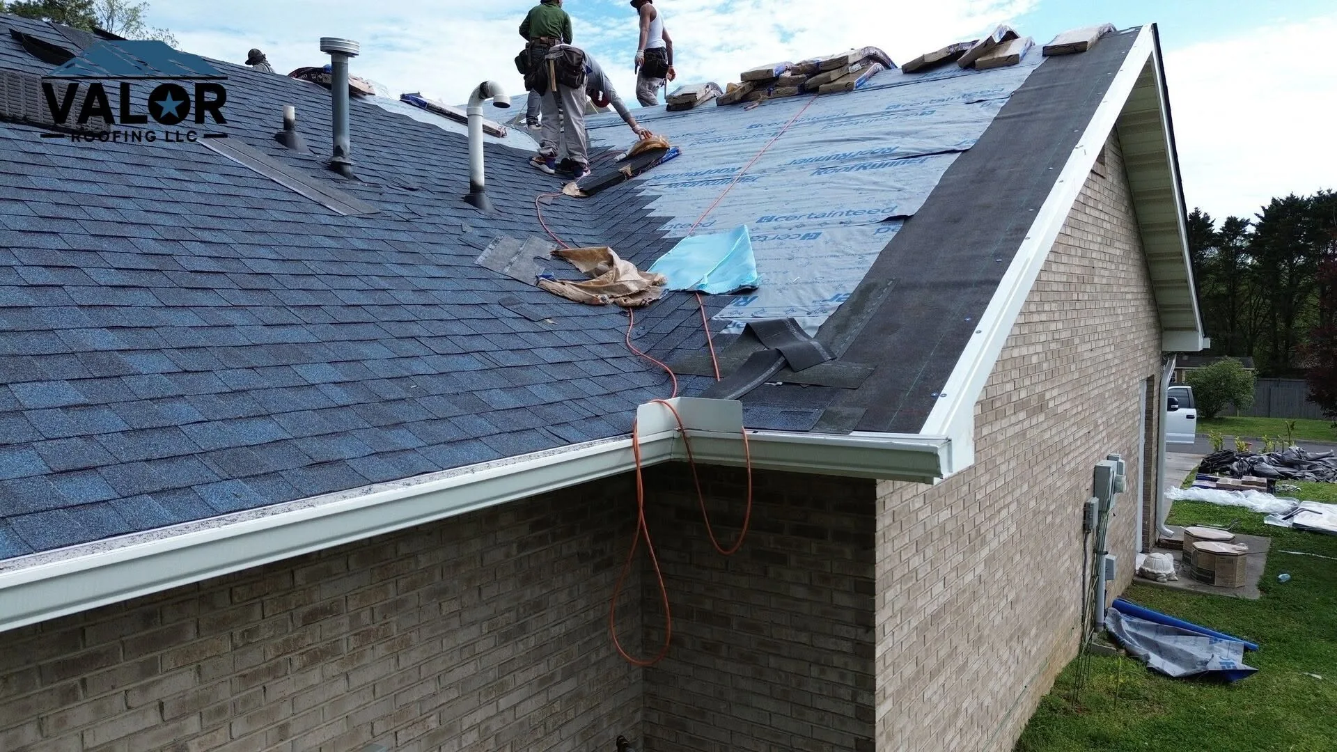 Roofer installing asphalt shingles over synthetic underlayment