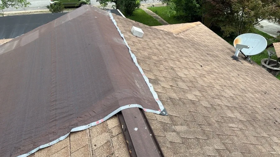 Section of roof with fresh underlayment patched into older shingles