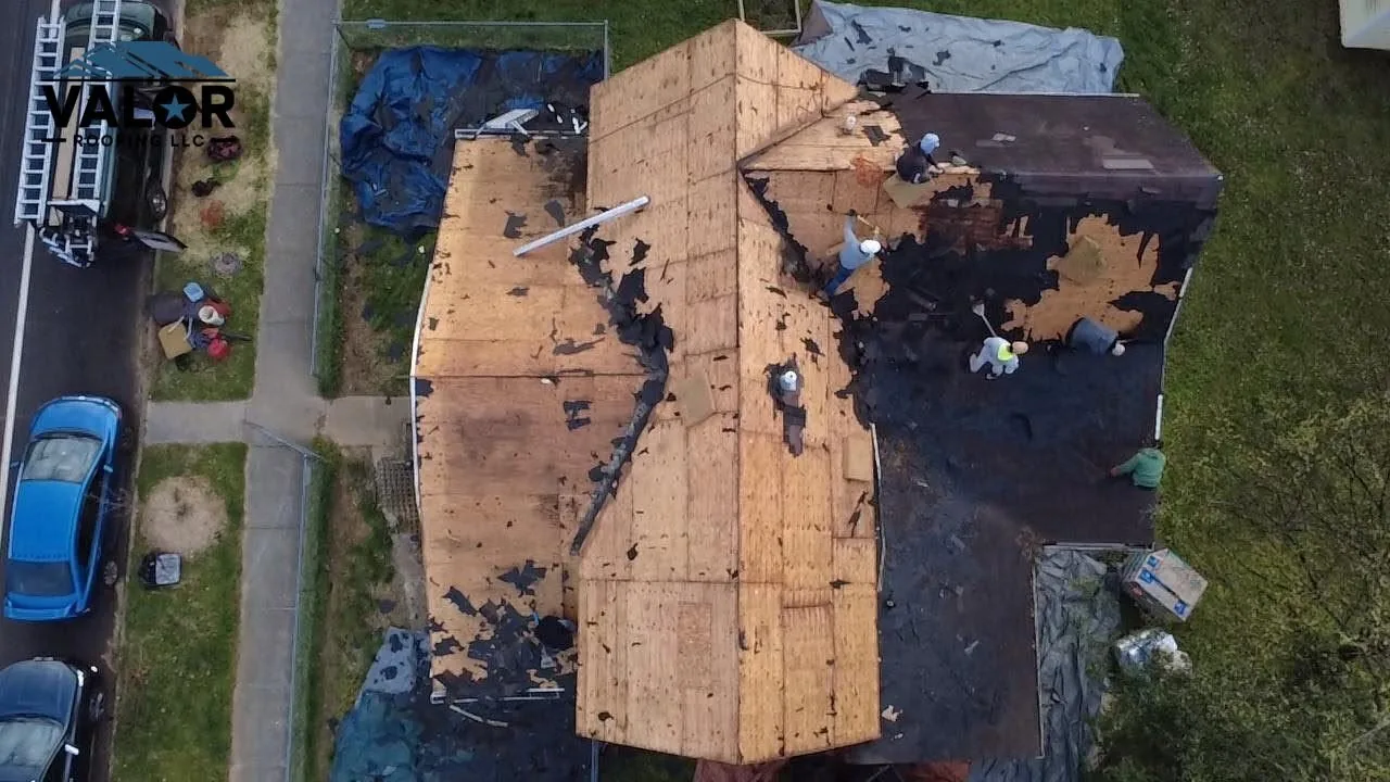 Drone view of a roof tear-off in progress, stripped down to the decking